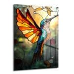 Vitray Kolibri Sanatı: Canlı Renklerle Işıldayan Temperli Cam Tablo. Turuncu, kırmızı, mavi ve yeşil tonlarında vitray tarzı bir kolibrinin yer aldığı, ışık saçan, dekoratif temperli cam duvar sanatı.