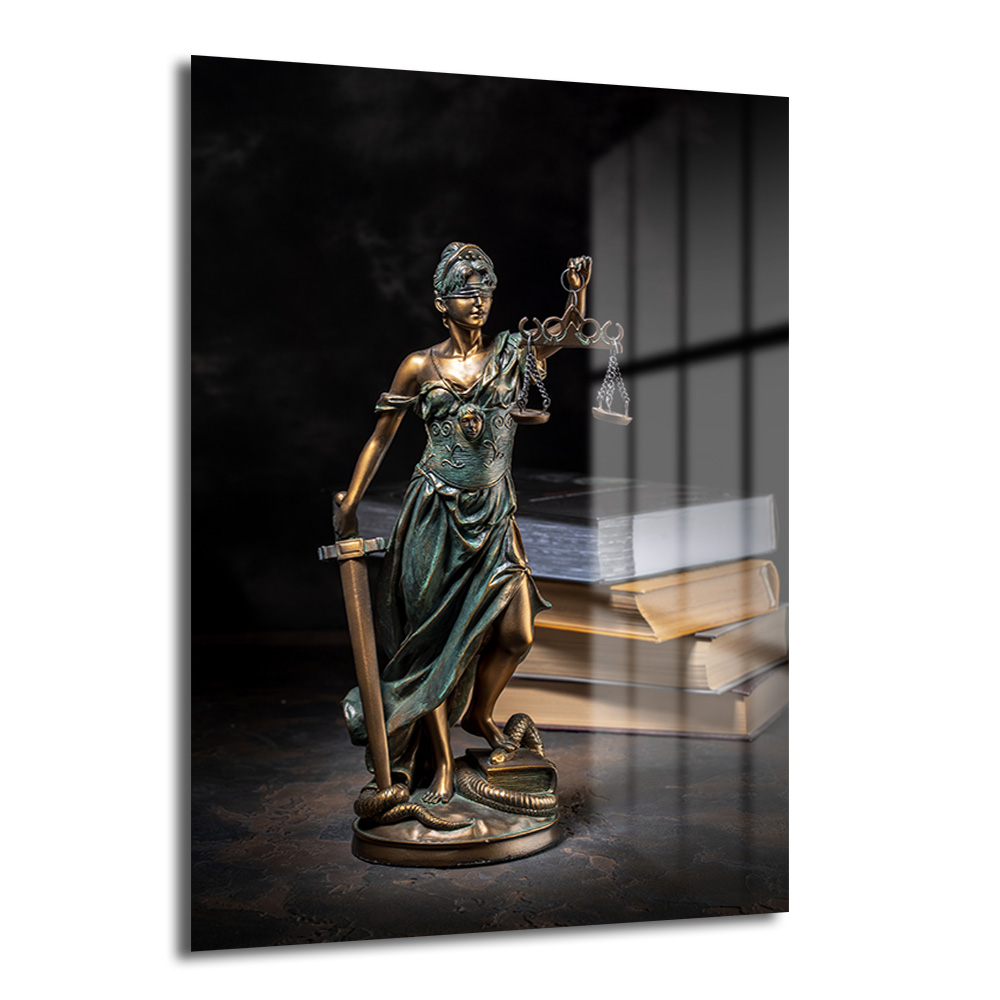 Adalet Tanrıçası Themis Cam Tablo - Hukukun Sembolü Duvar Dekoru Karanlık bir arka planda, gözleri bağlı, bir elinde terazi, diğer elinde kılıç tutan, ayaklarının dibinde yılan olan bronz renkli Themis (Adalet Tanrıçası) heykeli ve arka planda kitaplar bulunan cam tablo.