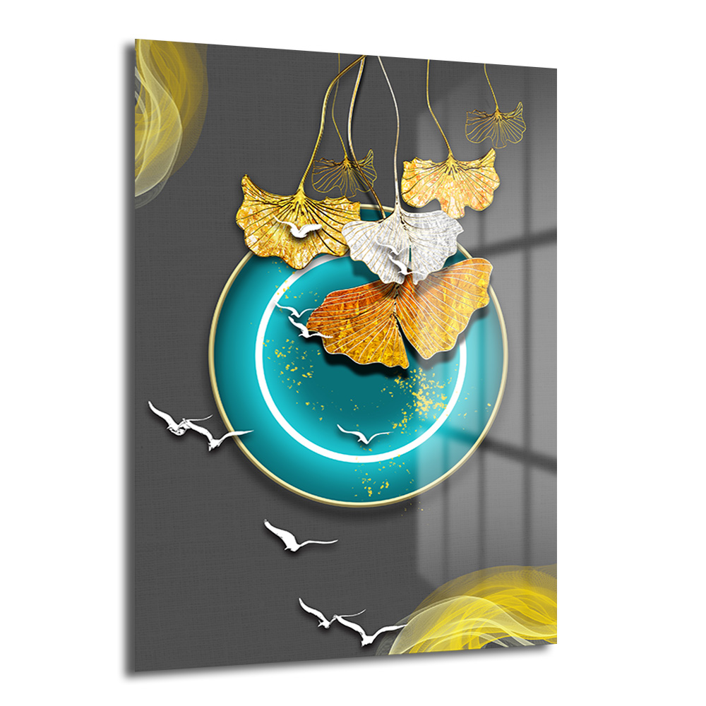 Ginkgo Yaprakları ve Teal Çemberli Modern Sanat Cam Tablo Duvar Dekoru Koyu gri fon üzerinde altın, beyaz ve turuncu ginkgo yaprakları, teal renkli bir çember ve etrafında uçuşan beyaz kuş figürleri içeren modern cam tablo.