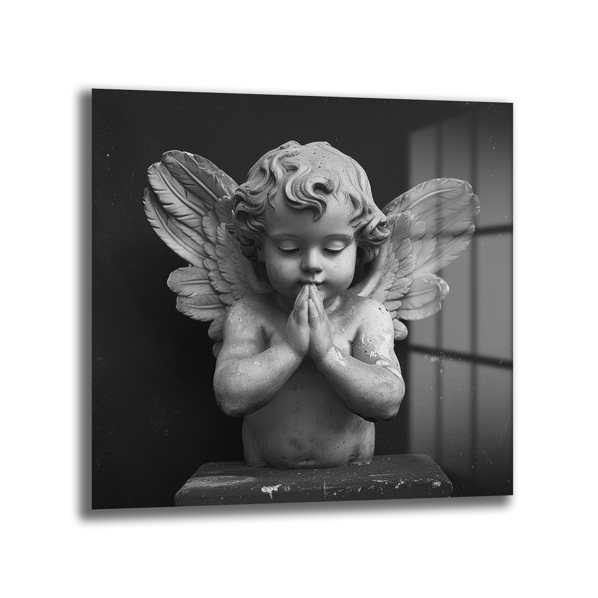Huzurlu Cherub Cam Tablo - Manevi Dokunuşla Ev Dekorasyonu Duvar Dekoru Siyah beyaz tonlarda, dua eden bir cherub (melek çocuk) heykelinin yakından çekilmiş fotoğrafı. Cherub'un gözleri kapalı, elleri göğsünde birleşmiş ve yüzünde huzurlu bir ifade var. Arkası karanlık, sağ tarafta pencere benzeri ışık yansımaları görülüyor. Heykelin dokusu ve detayları belirgin.