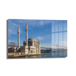 İstanbul'un Kalbinden: Ortaköy Camii ve Boğaz Köprüsü Cam Tablo, Ortaköy Camii'nin zarif mimarisi ve Boğaz Köprüsü'nün ihtişamlı siluetini mavi gökyüzü ve denizle birleştiren dekoratif bir cam tablo.