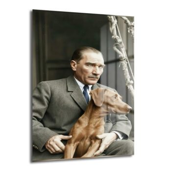 Mustafa Kemal Atatürk'ün gri takım elbisesiyle otururken kahverengi köpeği Foks'u kucağında tuttuğu, ikisinin de aynı yöne baktığı, tarihi ve duygusal bir anı yansıtan cam tablo.