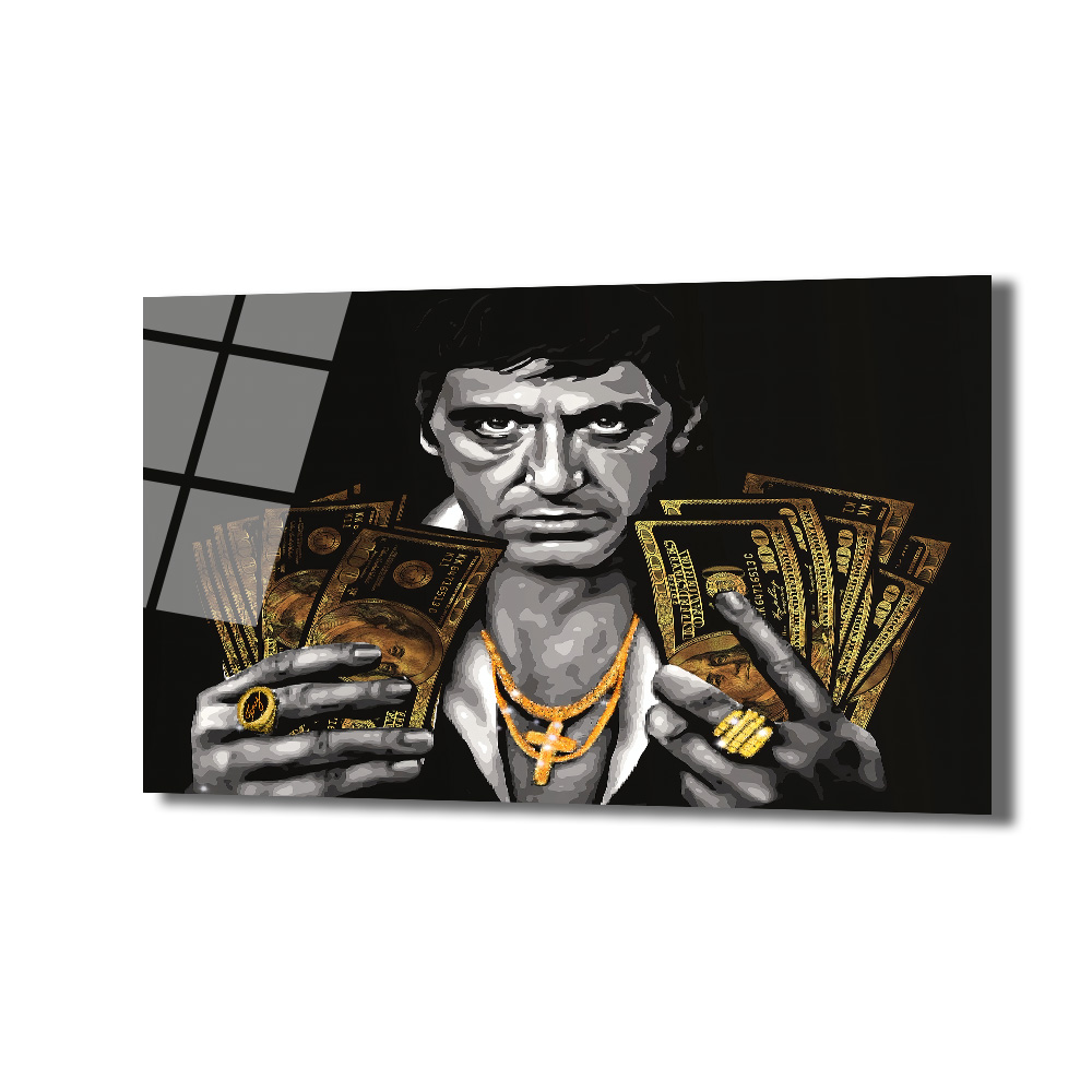 Tony Montana Efsanesi Altın Detaylı Cam Tablo Duvar Dekoru Siyah beyaz tonlarda, elinde altın renkli banknotlar tutan, altın kolye ve yüzük takmış, sert bakışlı bir adamın portresi. Sağ üst köşede camın yansıması görülüyor.